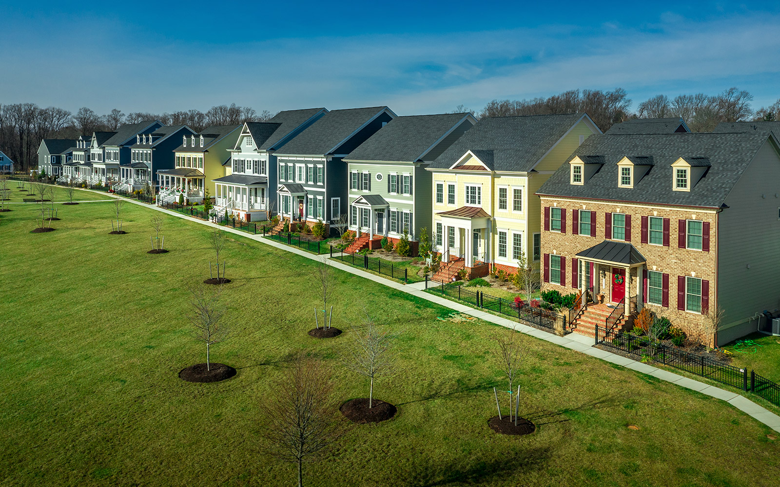 Single family home community with large shared grass area in front of homes